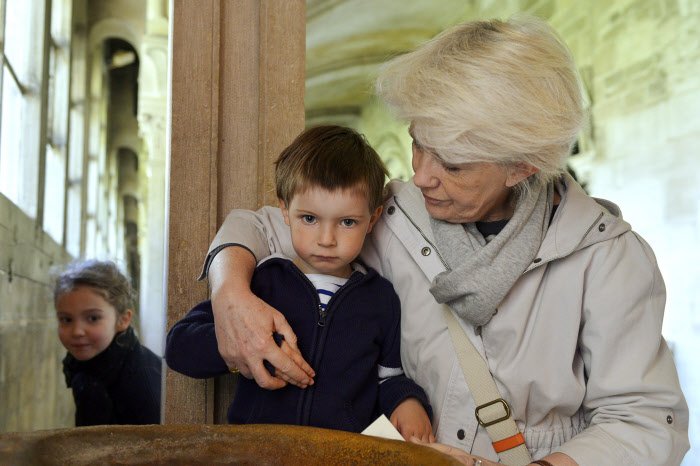23 avril 2014 : Une grand-mère faisant le signe de croix avec son petit-fils de 3 ans, cloître de la basilique de Vézelay. Vézelay (89), France.