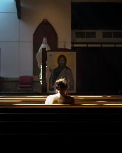Jeune fille en prière dans une église.