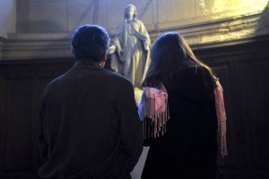Un couple prie devant une statue de la Vierge .