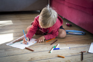 20 octobre 2018 : Illustration. Petit garçon dessinant, assis sur le sol de la maison. France.