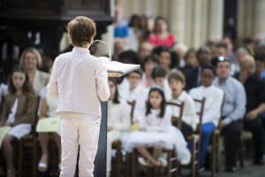 23 juin 2019 : Premières communions. Lecture par un jeune communiant lors de la messe célébrée en la paroisse Saint Jean Baptiste de Belleville, Paris (75), France.